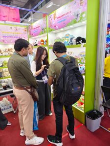 Overseas buyers discussing custom plush toy options with staff at the Canton Fair booth