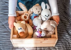 a wooden box of plush toys
